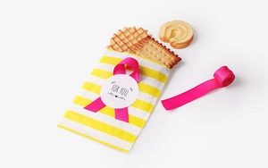 Detail of a gift set with yellow striped paper bag, pink ribbon and 'FOR YOU' sticker