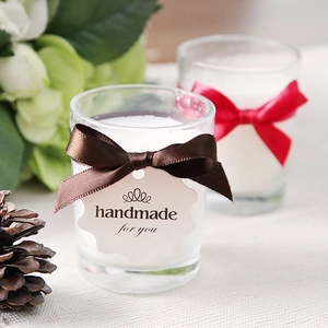 Handmade scented candles in glass jars with silk ribbon bows for wedding gift favors
