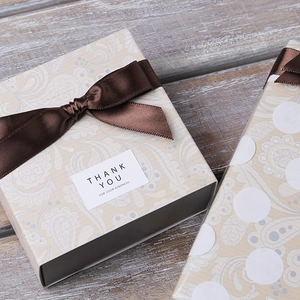 Elegant floral and polka dot gift boxes with satin ribbon bows on vintage wood background