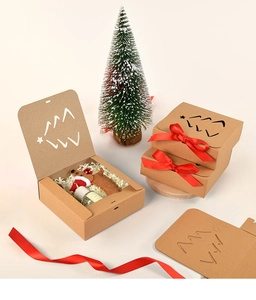 Macro view of brown kraft gift box with hollow Christmas tree and red ribbon bow