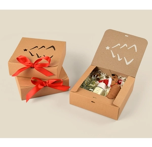 Detail of kraft paper Christmas gift box with cutout tree and red satin bow ribbon