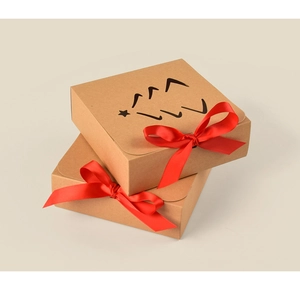 Detail of kraft paper gift box with red bow and star Christmas tree cutout design