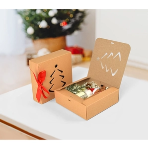 Detail of kraft paper gift boxes with red ribbon and Christmas tree cutout design