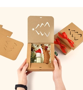 Detail of kraft paper gift box featuring festive cutout tree design and red ribbon