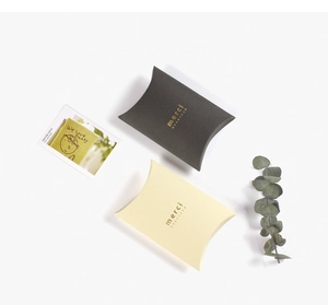 Detail of small pillow gift boxes with gold foil merci beaucoup lettering on paper