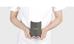 Detail of small black matte pillow gift box with gold merci beaucoup foil stamping