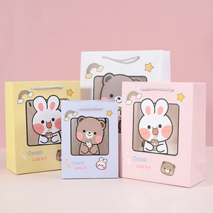 Detail of cute cartoon bunny gift bags with transparent window and woven handles