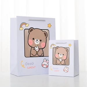 Detail of purple gift bags featuring cute cartoon bear illustration and braided handles