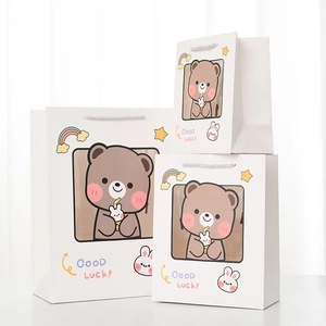 Detailed set of three white paper gift bags with cute bear prints and woven handles