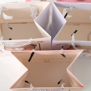 Top-down view of cartoon gift bags showing star-shaped opening and durable woven handles