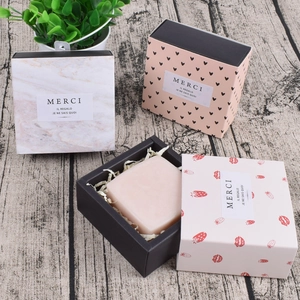 Quadratische Geschenkboxen mit Marmormuster und Schubladendesign auf Holzboden