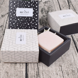 Elegantes cajas de regalo cuadradas con patrones geométricos y etiquetas Merci Beaucoup