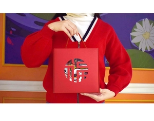 Detail of red Chinese New Year gift box with Fu character cutout and golden handle