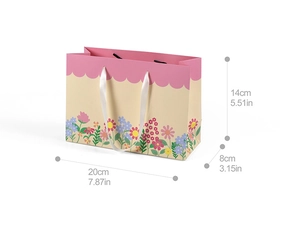 Close-up of floral paper gift bag with 20x8x14cm size dimensions and ribbon handles