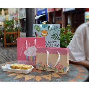 Detailed view of floral gift bags with ribbon handles and Happy Everyday printing