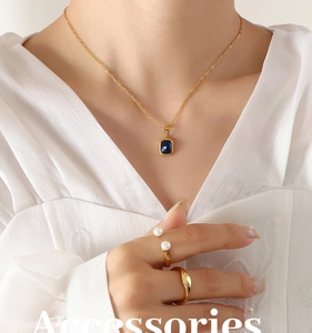 Détail du collier plaqué or 18K avec cristal bleu et bague en perle sur le mannequin