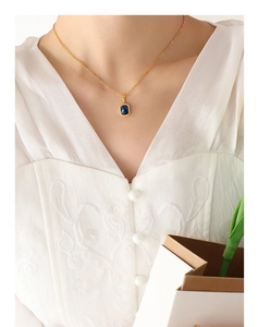 Gros plan d'un collier plaqué or 18 carats avec pendentif cristal bleu sur un mannequin