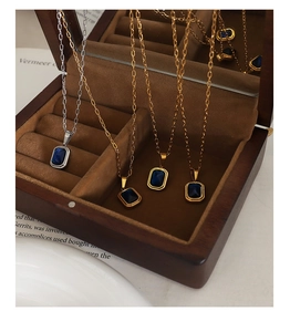 Détail de colliers plaqués or 18K avec pendentifs en cristal bleu rectangulaire en coffret