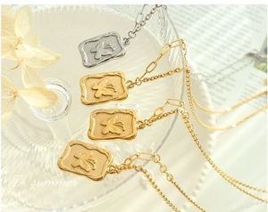 Close-up of vintage butterfly relief square pendants on textured glass tray