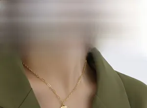 Close-up of a gold butterfly heart pendant with asymmetrical chain on a model