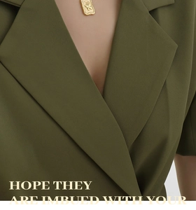 Detail of vintage gold butterfly square pendant on olive green textured suit fabric