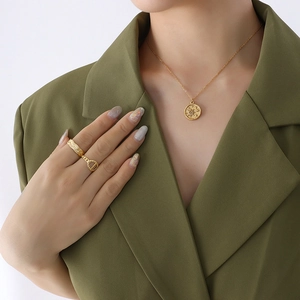 Star and moon gold pendant necklace with minimalist rings set on professional model
