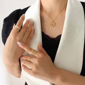 Gold celestial sun moon pendant necklace and textured geometric rings set on a model