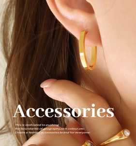 Macro de boucles d'oreilles créoles dorées minimalistes portées sous lumière chaude