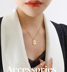 Close-up of gold oval relief pendant necklace featuring abstract female body silhouette