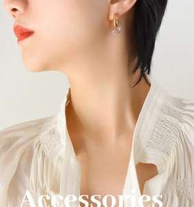 Close-up of interlocking gold and silver dual-tone hoop earrings on a female model