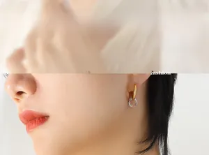 Detailed view of interconnected gold and silver hoop earrings on a female model