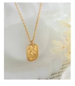 Detailed macro view of an oval embossed female body outline pendant on a gold O-chain necklace