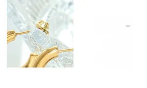 Detailed close-up of gold-plated titanium steel interlocking hoop earrings on textured glass