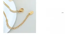 Détail du fermoir mousqueton en acier doré et du médaillon gravé K18