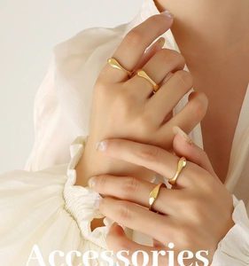 Close-up of a 4-piece set of 18k gold plated irregular wave rings on model's hand