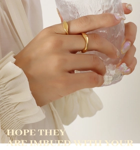 Close-up of a golden irregular geometric ring set with a liquid metal texture finish