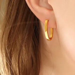 Boucles d'oreilles créoles dorées en forme de U en acier titane sur un mannequin