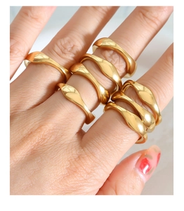 Close-up of stacked 18k gold plated stainless steel rings with organic wavy design