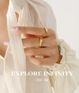 Detail showing two irregular wavy gold rings stacked on a model hand with premium finish