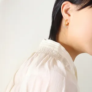 Fashionable gold and silver interlocking metal hoops earrings worn by model for elegant style