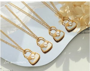 Détail de mini pendentifs sac à main avec incrustation nacre et perles sur chaînes dorées