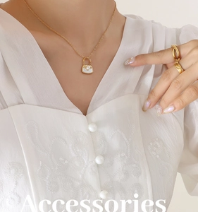 Vue détaillée d'un collier pendentif sac à main doré avec perle sur un mannequin