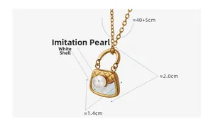 Détail macro du pendentif sac à main doré avec perle et incrustation de nacre