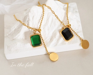 Détail du collier long doré ajustable avec cristal émeraude et médaille ronde