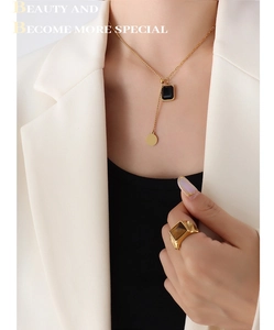 Détail du collier à gland doré avec cristal carré et médaille ronde sur mannequin