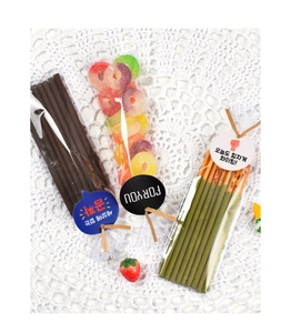 Detail of candy gift bags with chocolate biscuit sticks, fruit rings, and cute gift tags