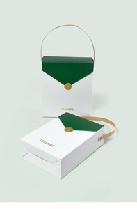 Détail du coffret cadeau blanc avec rabat vert, sceau doré et inscription en russe