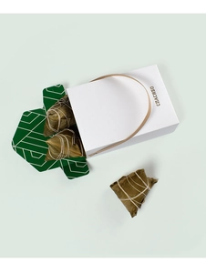Détail du coffret cadeau blanc minimaliste avec trois zongzi et doublure verte