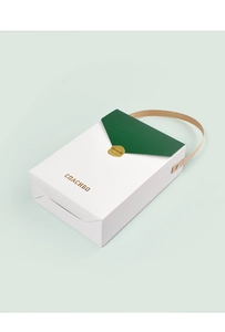 Vue détaillée du coffret cadeau blanc avec couvercle vert et poignée en cuir