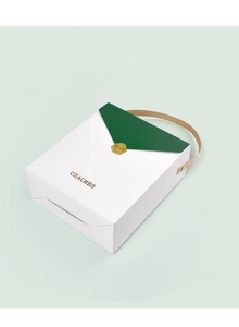 Boîte cadeau blanche épurée avec rabat vert, sceau doré et poignée marron élégante